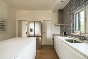 a kitchen with white counters and a stainless steel refrigerator at Bela Vista - Countryside home in Gradil +42 photos