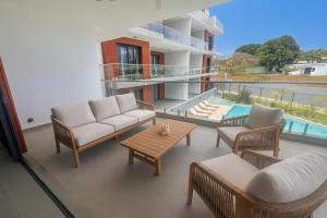 un balcon avec un canapé, des chaises et une table dans l'établissement Residence ORYAM, à Trou aux Biches