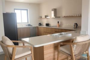 - une cuisine avec une table et deux chaises dans l'établissement Residence ORYAM, à Trou aux Biches 2 autres photos