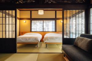 a bedroom with two beds and a couch at Hotel Hanakoyado in Kobe