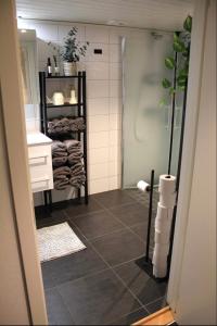 a bathroom with a shower and a tile floor at Gamletull Guesthouse in Halmstad