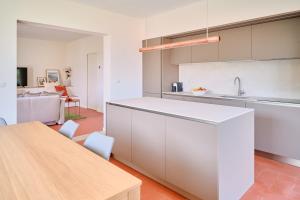 a kitchen with white cabinets and a wooden table at Casa Terracotta in Cremia