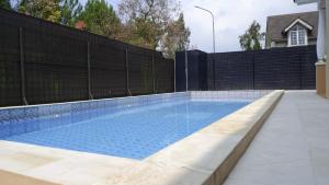 a swimming pool in a backyard with a fence at Villa Dalia Puncak Nb4-01 in Cikundul