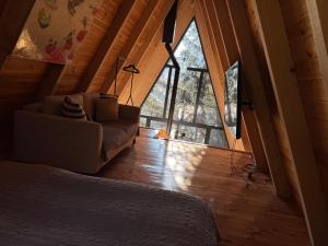 a living room with a couch and a large window at PinePano Lodges in Žabljak