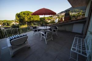 a patio with a table and chairs and an umbrella at Villa Lina B&B in San Felice Circeo