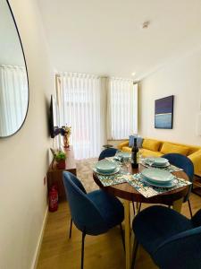 a living room with a table and blue chairs at Old Porto - Tiny House & Apartment Luxury Garden by MyMoradia in Porto
