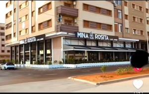 纳祖尔Panorama Apartment Nador Jadid Klima Parking Only Family的一栋前面有停车场的建筑物