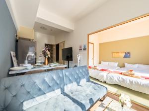 a living room with a bed and a couch at Newly opened Hotel 3 京セラドーム徒歩10分 道頓堀 関西空港 大阪城 海遊館直行 USJ1回乗換 出張 Family friendly Free parking 15 minutes by car to USJ in Osaka