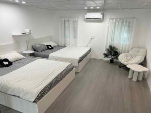 a room with two beds and a chair in it at HOMIE Stay in Hai Phong