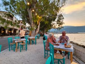 a group of people sitting at tables on the beach at Cedar House a Greek treasure in Sami