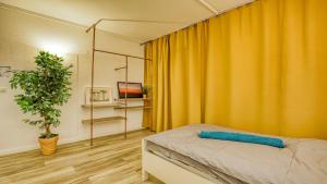 a bedroom with a bed with an orange curtain at Unperfekthotel CoWorkingHotel in Essen