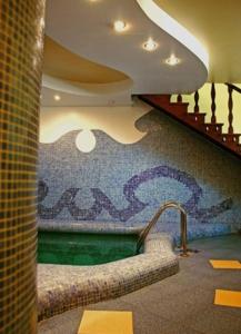 a swimming pool in a room with a mosaic wall at Valentyna in Lviv