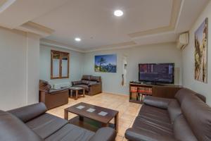 sala de estar con sofás y TV de pantalla plana. en Hotel Rural Huerta del Laurel, en Monachil