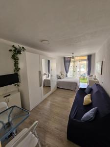 sala de estar con sofá y cama. en Estudio Stephane Chapparal Costa del silencio, en Las Galletas