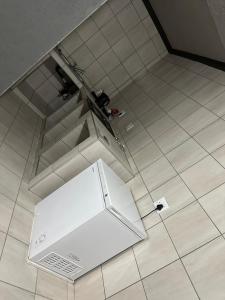 - un réfrigérateur blanc installé sur un sol carrelé dans l'établissement The Hope Apartments, à Nelspruit