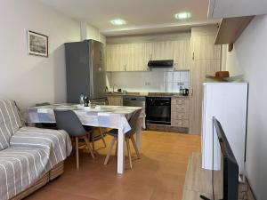 Una pequeña cocina con una mesa y un sofá. en Encantador Apartamento dúplex con vistas al mar, en Canet de Berenguer