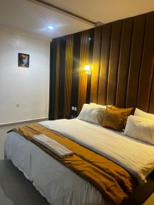 Un dormitorio con una cama grande con cabecero de madera. en The Ridge Hotel and Bar, en Uyo