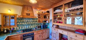 アボンダンスにあるLe Carolien - Ferme traditionnelle rénovéeの木製キャビネットとコンロ付きの広いキッチン +17枚の写真