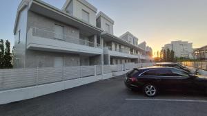 a black car parked in a parking lot next to a building at La dimora di Matteo in Marina di Montenero