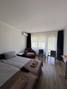 a bedroom with a bed and a couch and chairs at Мотель "Козачок" з рестораном у Чинадієві in Mukacheve