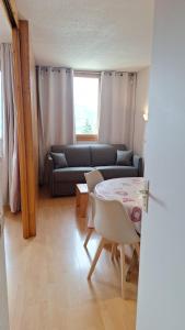 a living room with a couch and a table at APPART ZIG-ZAG LES COCHES in Les Coches