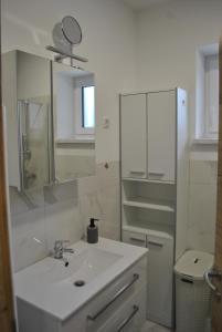 a white bathroom with a sink and a mirror at Prenočišča Dany APARTMA 1 in Dravograd