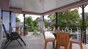 a dining room with a table and chairs on a patio at Villa Dalia Puncak P2-12 in Tjiandjur