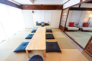 a living room with a long table and blue pillows at Miraie Yokkaichi Heizucho in Yokkaichi