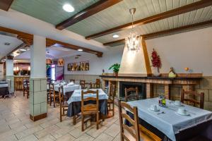 un restaurante con mesas y sillas y una chimenea en Hotel Rural Huerta del Laurel, en Monachil