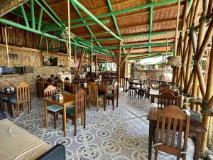 a dining room with tables and chairs in a restaurant at Hotel Oasis Port Barton in San Vicente
