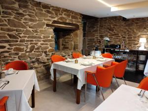 a restaurant with a white table and orange chairs at Posada Real La Pascasia in Puebla de Sanabria