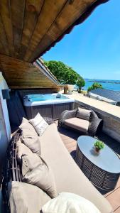 a patio with a couch and a table and a hot tub at Villa Bellavista in Kavarna