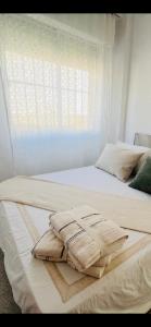 two beds with white sheets and a window at Sun & Salt Lo Pagan in San Pedro del Pinatar