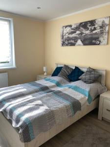 a bedroom with a large bed with blue and gray sheets at Apartament Koszarawa in Koszarawa
