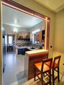 a kitchen with two chairs and a counter and a kitchen with a stove at HRISHI Guest Suites 3Bhk in Trivandrum