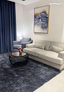 a living room with a couch and a table at Abu Rakan Apartment in Muscat