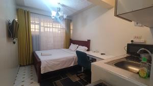 a small room with a bed and a sink at Highway Studio Kinoo in Kikuyu