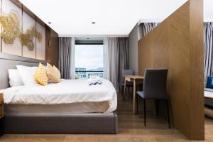 een hotelkamer met een bed en een bureau bij Bright 41 m² Condo Pools Beach Shuttle S6502 in Rawai Beach +50 foto's