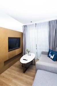 a living room with a couch and a table at Suite Aura 1BR PoolsGyms Shuttle to Nai Harn in Rawai Beach