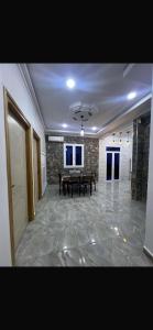 a large room with a table and a stone wall at Appartement familial et calme proche des plages & Alger in Mahelma