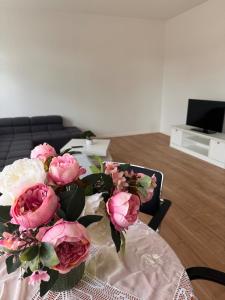 a vase of pink flowers on a table at 2 Bedroom Apartment at Grenzach train station in Grenzach-Wyhlen +3 photos