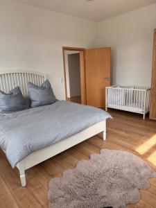 a bedroom with a bed with blue pillows and a crib at 2 Bedroom Apartment at Grenzach train station in Grenzach-Wyhlen +3 photos