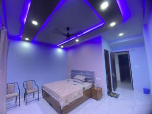 a bedroom with a bed and purple lights on the ceiling at Revanta Home Stay in Anandpur Sāhib