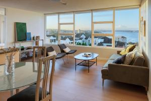 a living room with a couch and a table at Panoramic Harbour View Apartment in Sydney