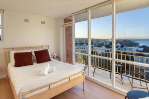 a bedroom with a bed and a large window at Panoramic Harbour View Apartment in Sydney