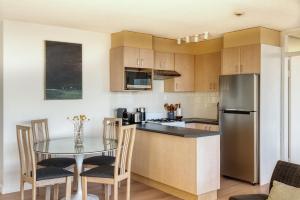 a kitchen with a table and a stainless steel refrigerator at Panoramic Harbour View Apartment in Sydney +12 photos