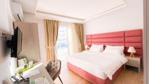 a bedroom with a large bed with a red headboard at Luna Rooms in Golem