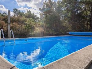 una piscina blu con alberi sullo sfondo di 6 person holiday home in Nexø a Neksø