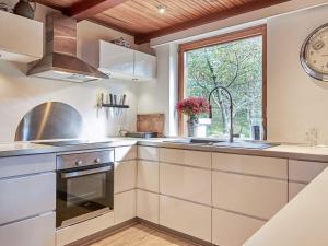 una cucina con mobili bianchi e una finestra di 6 person holiday home in Nexø a Neksø