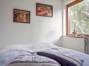 un letto in una camera da letto con due quadri sul muro di 6 person holiday home in Nexø a Neksø Altre 13 foto